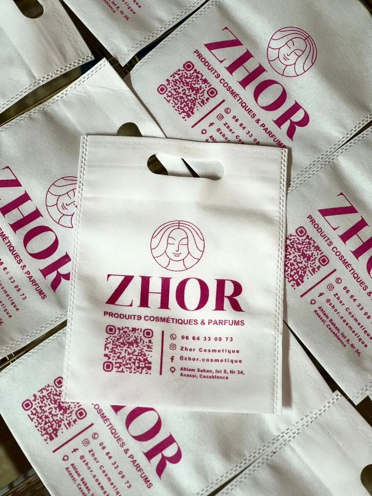 Photo des sacs imprimés au logo de la boutique, empilés